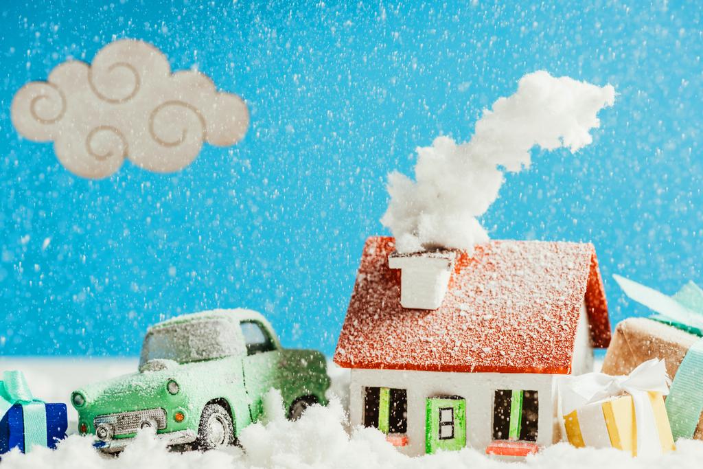κοντά shot της μικρογραφία αυτοκίνητο με τα δώρα Χριστουγέννων και σπίτι που καλύπτεται με το χιόνι - Φωτογραφία, εικόνα