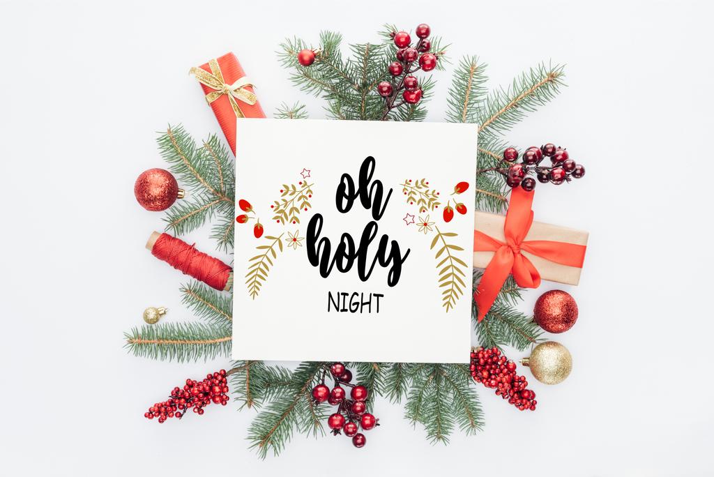 top view of pine tree branches, christmas decorations and gifts  with "oh holy night" lettering in middle isolated on white - Photo, Image