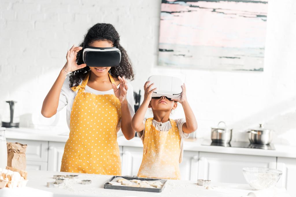 madre e hija afroamericana preparando masa en auriculares de realidad virtual en la cocina
 - Foto, imagen