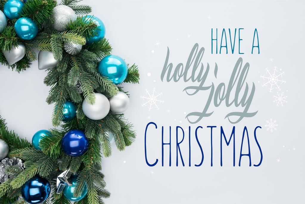 κάτοψη του διακοσμητικό γιορτινό στεφάνι με μπλε και ασημένια Χριστούγεννα toys απομονωθεί σε λευκό με «έχουν ελαιόπρινο ευχάριστα Χριστούγεννα» έμπνευση  - Φωτογραφία, εικόνα
