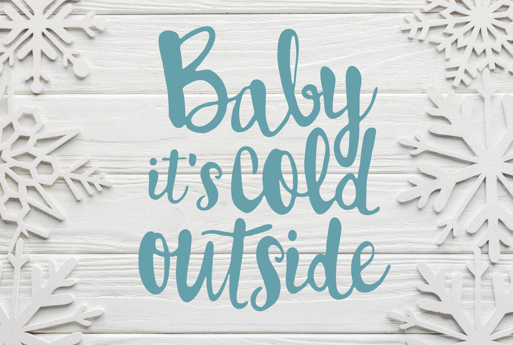 tasainen makasi koriste lumihiutaleet valkoinen puinen tausta "Baby sen kylmä ulkona" kirjoitus
  - Valokuva, kuva
