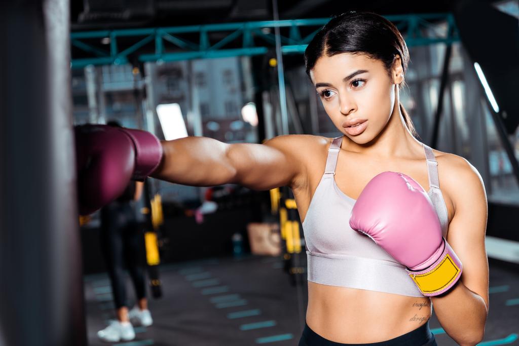 Atractiva chica boxeadora en guantes de boxeo lanzando golpes en el gimnasio
  - Foto, imagen