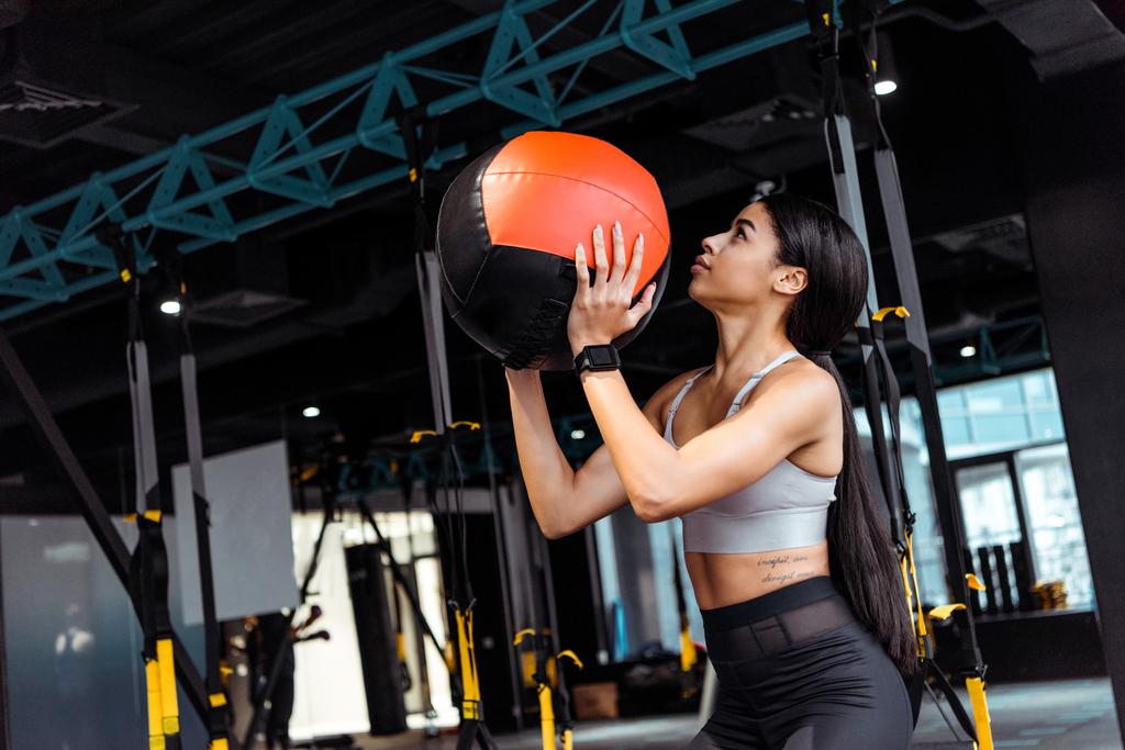 Приваблива спортивна дівчина тренується з медичним м'ячем у фітнес-центрі
 - Фото, зображення