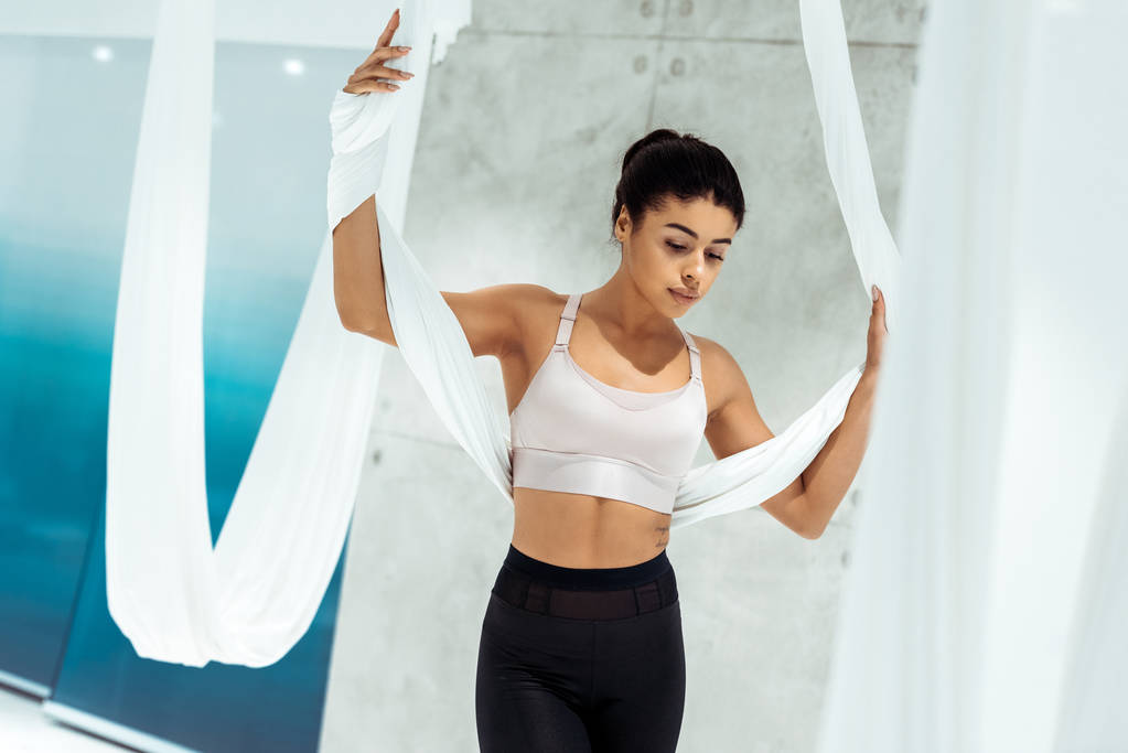 Atractiva chica deportiva practicando yoga en hamaca en estudio
 - Foto, Imagen