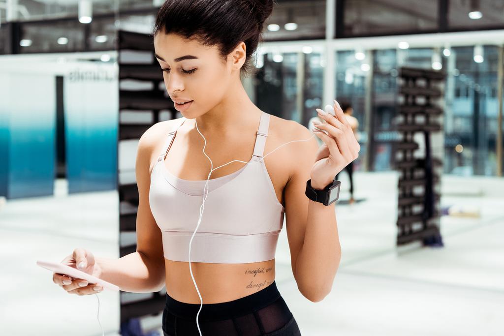 Чудесная спортивная девушка слушает музыку в фитнес-зале
 - Фото, изображение