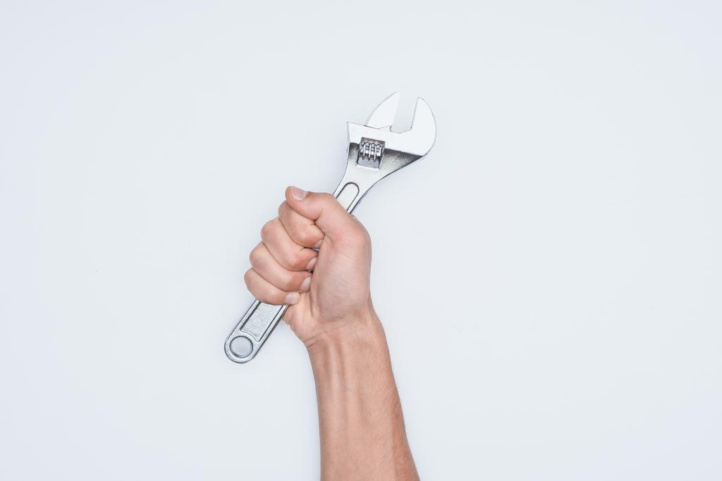 tiro cortado do homem segurando chave ajustável isolado no branco
 - Foto, Imagem