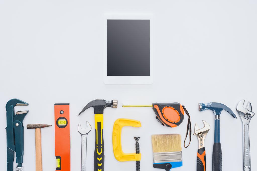 Ansicht des Tablets von oben mit verschiedenen Werkzeugen, die auf weiß liegen - Foto, Bild
