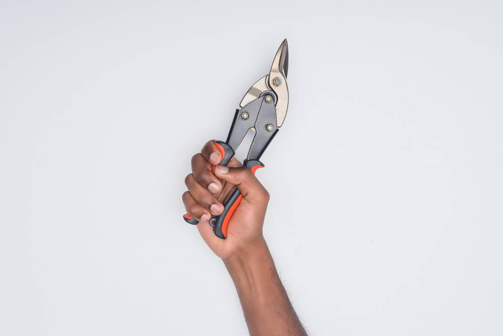 Colpo ritagliato di uomo afro-americano con pinze metalliche isolate su bianco
 - Foto, immagini