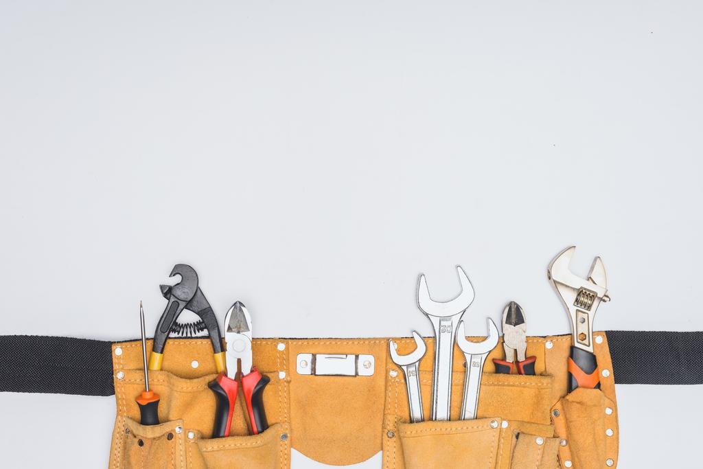 верхний вид пояса инструмента с инструментами ремонтника изолированы на белом
 - Фото, изображение