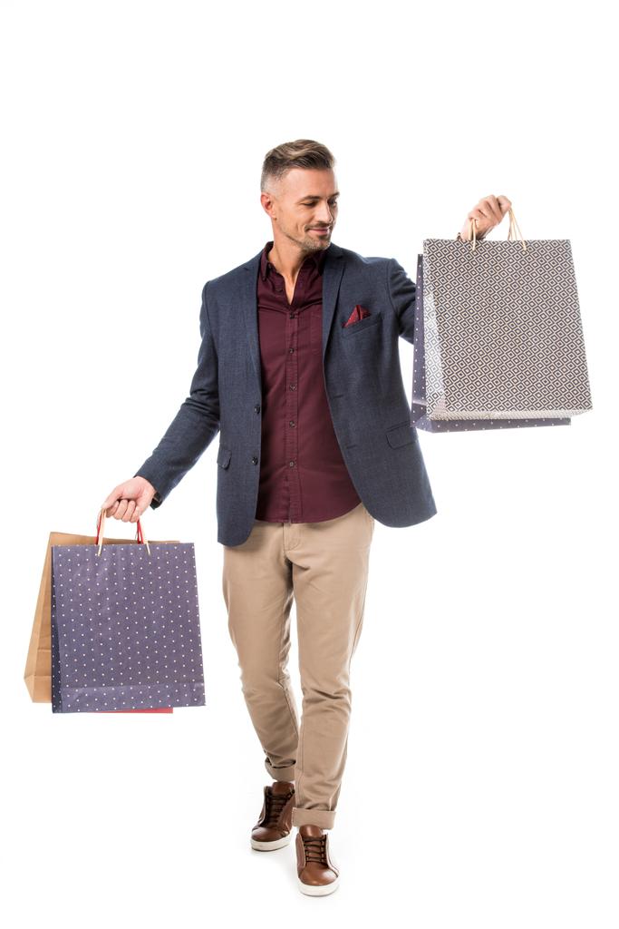 felice maschio shoppper in giacca a piedi con sacchetti di carta colorati isolati su bianco
 - Foto, immagini