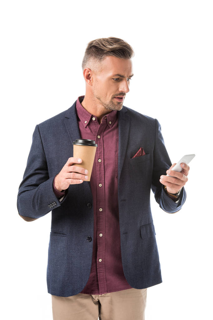 Tek kullanımlık kahve fincan beyaz izole smartphone kullanarak duygusal şık adam - Fotoğraf, Görsel