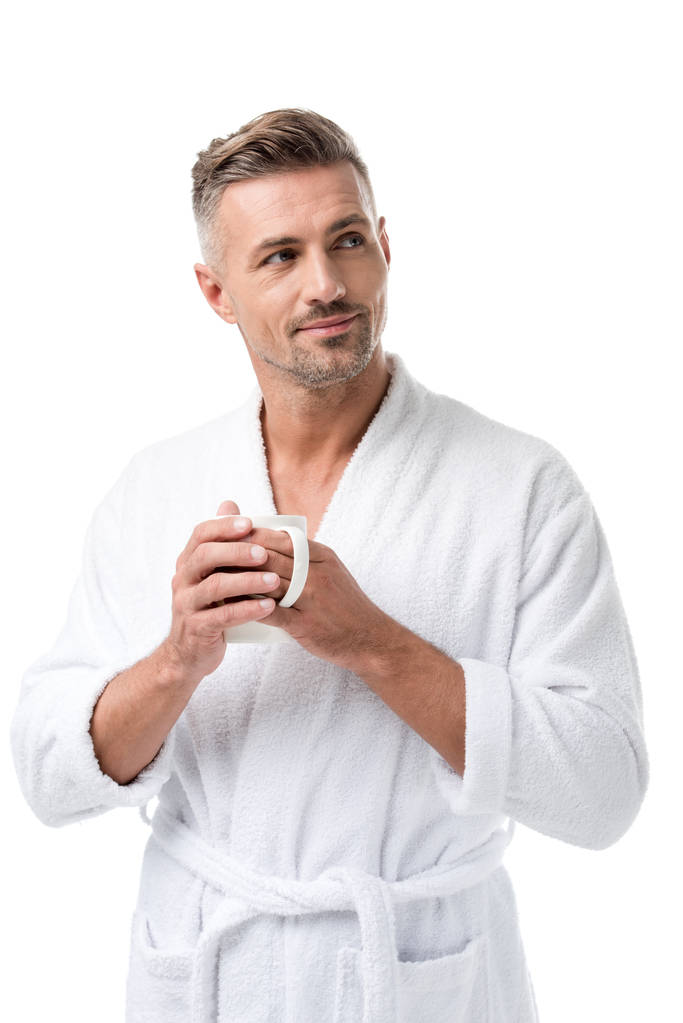 щасливий дорослий чоловік у халаті тримає чашку кави ізольовано на білому
 - Фото, зображення