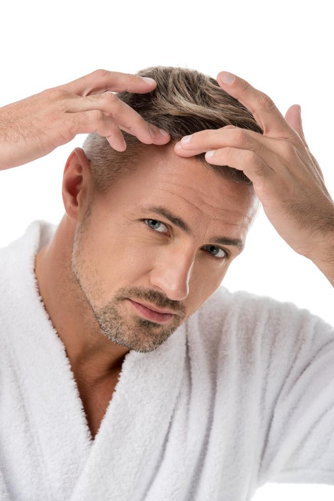 retrato de homem adulto em roupão de banho verificando-se para a perda de cabelo isolado no branco
 - Foto, Imagem
