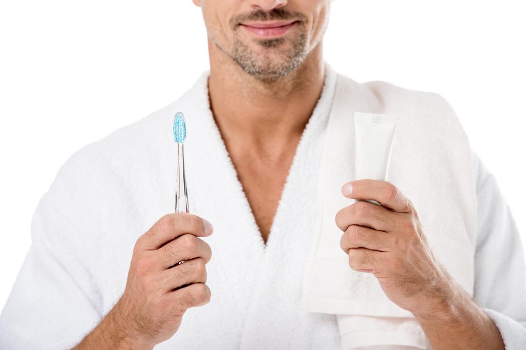 az ember a vállon fogkrém és fogkefe elszigetelt fehér törölközővel fürdőköpenyt részleges megtekintése - Fotó, kép