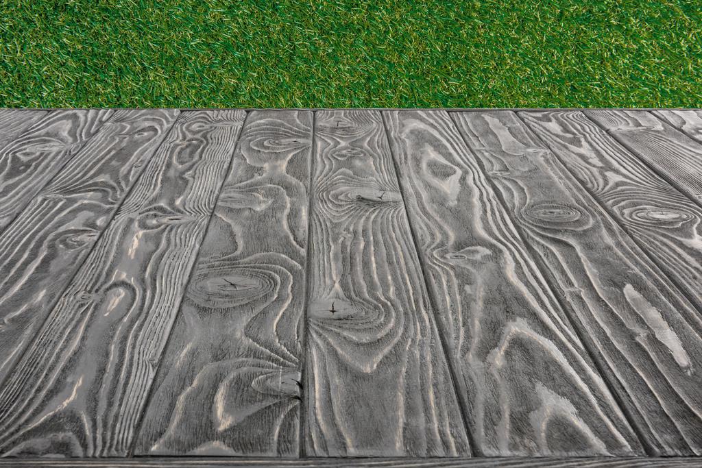  поверхня сірих дерев'яних дощок на фоні зеленої трави
 - Фото, зображення
