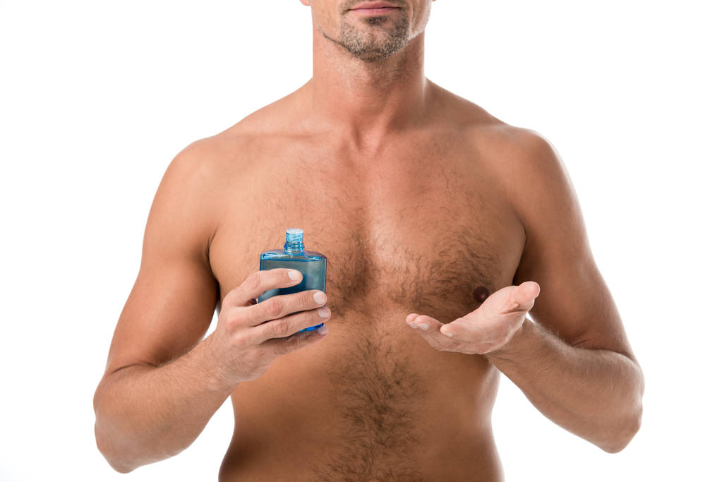 обрізане зображення без сорочки м'язистого чоловіка, що тримає лосьйон для гоління ізольовано на білому
 - Фото, зображення