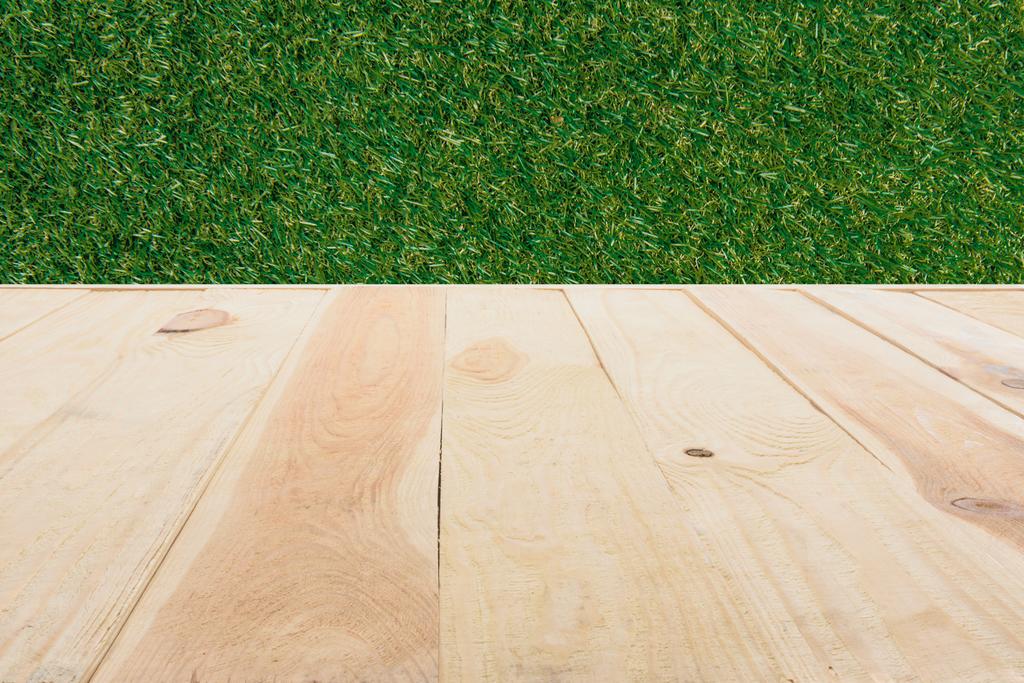template of beige wooden floor made of planks on green grass background - Photo, Image