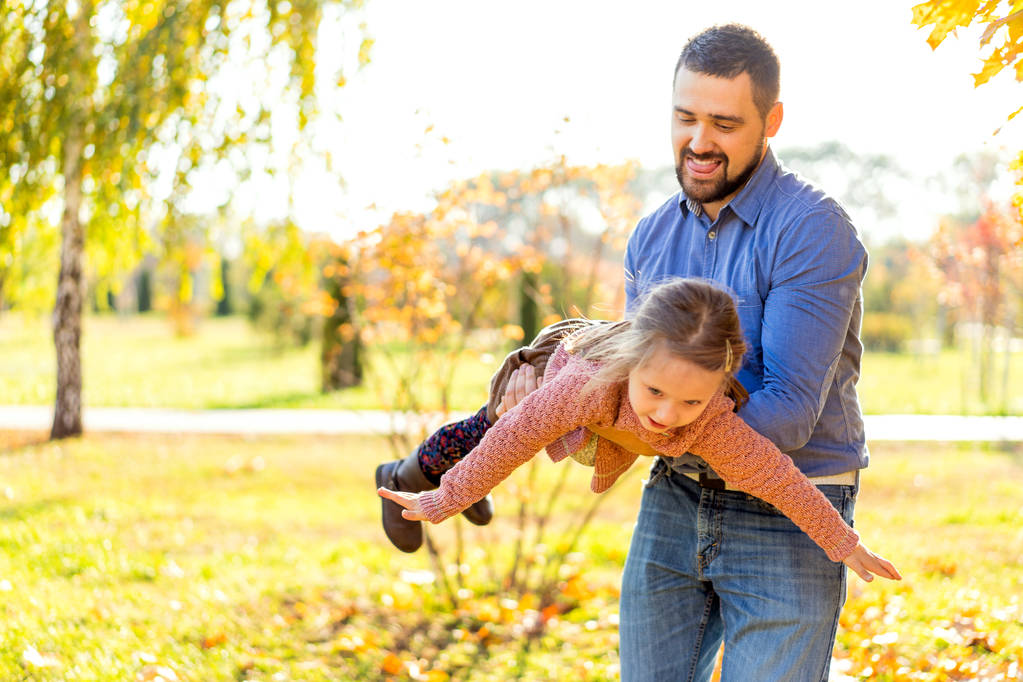 Vater und Tochter im Herbstpark spielen lachend - Foto, Bild