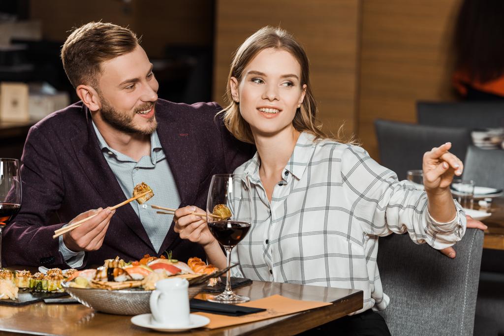 Ελκυστικό ζευγάρι που έχοντας δείπνο ενώ γυναίκα δείχνει κάτι στο εστιατόριο - Φωτογραφία, εικόνα