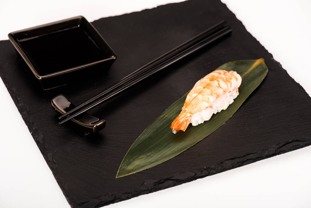 Nigiri sushi with shrimp served with chopsticks and soy sauce on black slate - Photo, Image