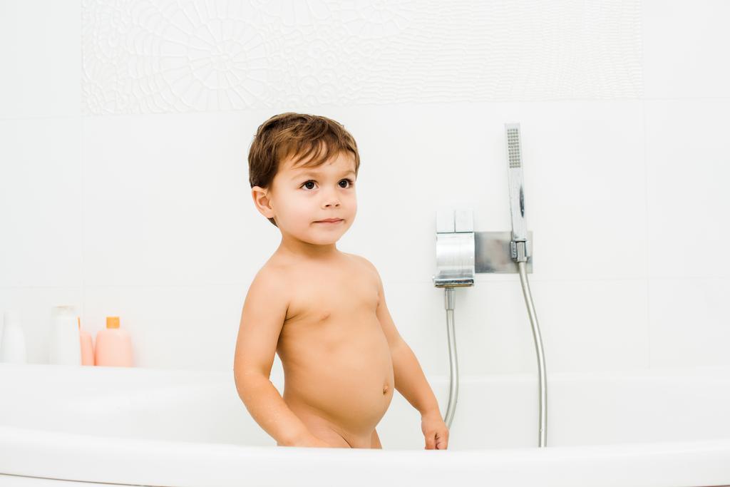 Niño pequeño de pie en blanco limpio baño blanco
 - Foto, Imagen