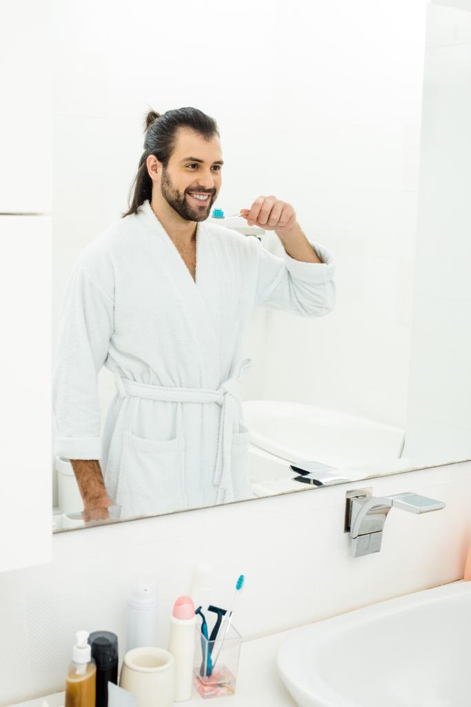 красивий дорослий чоловік чистить зуби у ванній
 - Фото, зображення