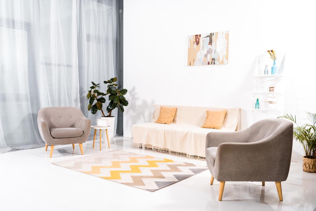 интерьер современной гостиной с ковровым покрытием, диваном и росписью на стене
  - Фото, изображение