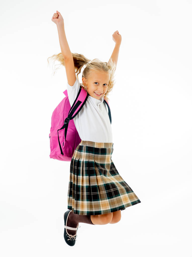 Αξιολάτρευτο όμορφη μικρή μαθήτρια με μεγάλα ροζ τσάντας αίσθημα ενθουσιασμένος και χαρούμενος να είναι πίσω στο σχολείο που απομονώνονται σε λευκό παρασκήνιο στο τέλος της έννοιας εκπαίδευση έτους και τα παιδιά. - Φωτογραφία, εικόνα