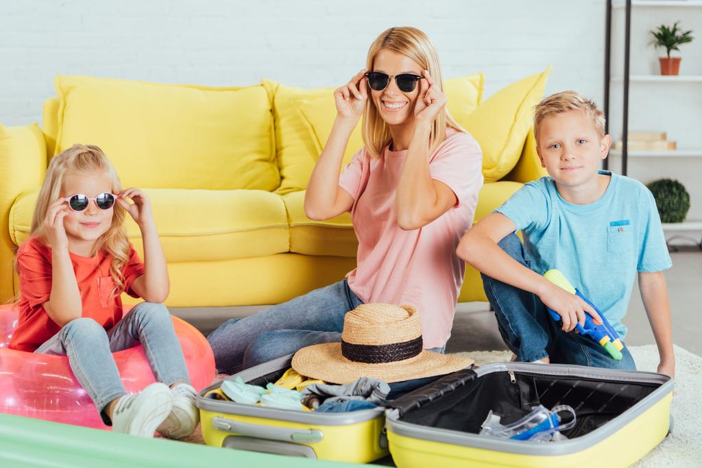 neşeli aile eğleniyor ve gözlük üzerinde çalışıyor yaz tatili için seyahat için kavram Bagaj paketleme  - Fotoğraf, Görsel
