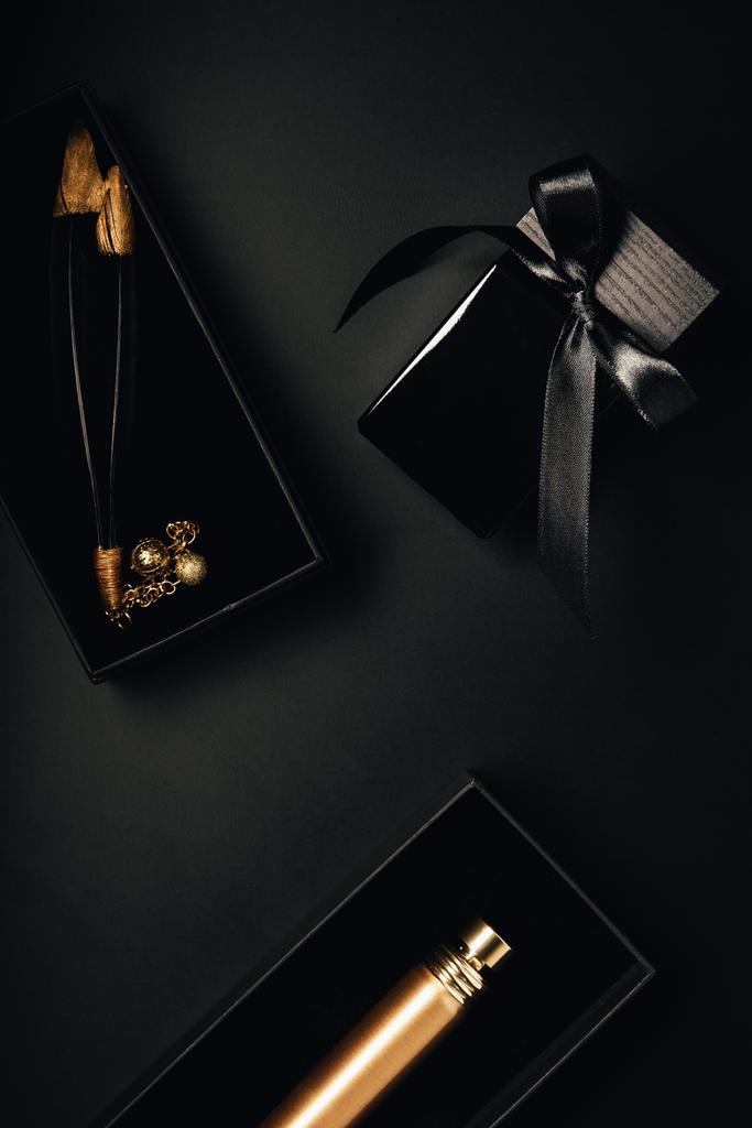 siyah şişe parfüm ve dekoratif tüyler üstten görünüm - Fotoğraf, Görsel