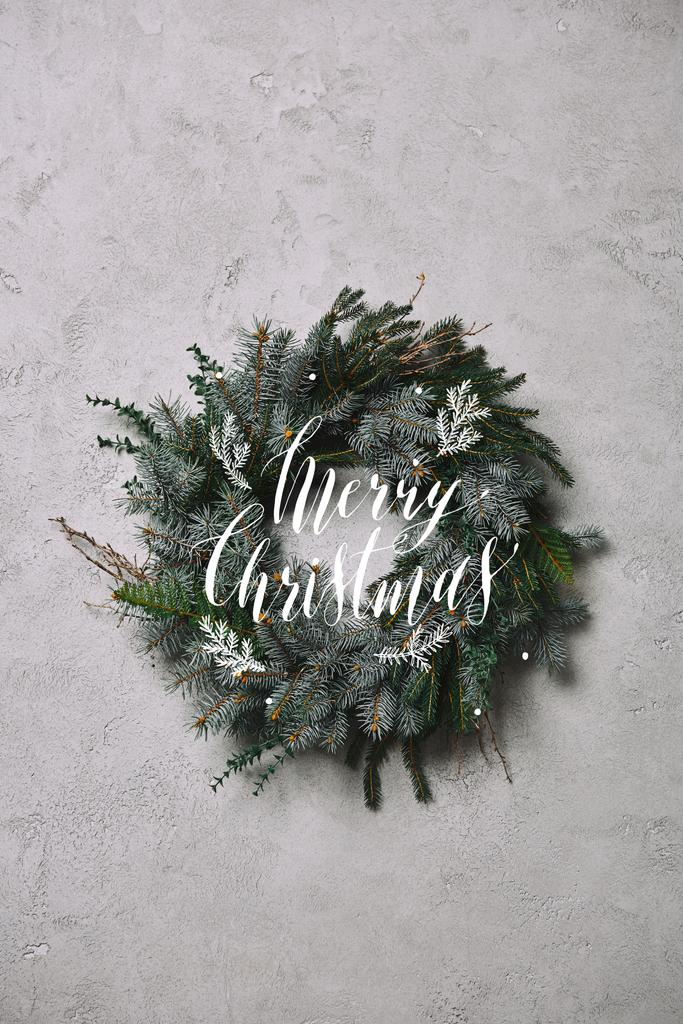 grinalda de abeto para decoração de Natal pendurado na parede cinza com letras "Feliz Natal"
 - Foto, Imagem