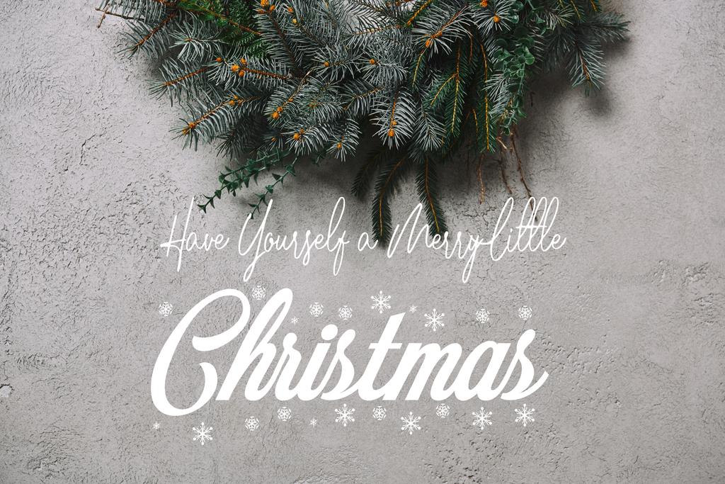 cropped image of fir wreath for Christmas decoration hanging on grey wall with "have yourself a merry little christmas" inspiration and snowflakes - Photo, Image