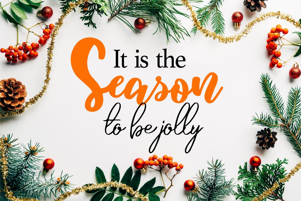 плоска лежала зі святковим розташуванням гілок сосни, обліпихою і різдвяними прикрасами на білому стільниці з "сезон веселим" натхненням
  - Фото, зображення