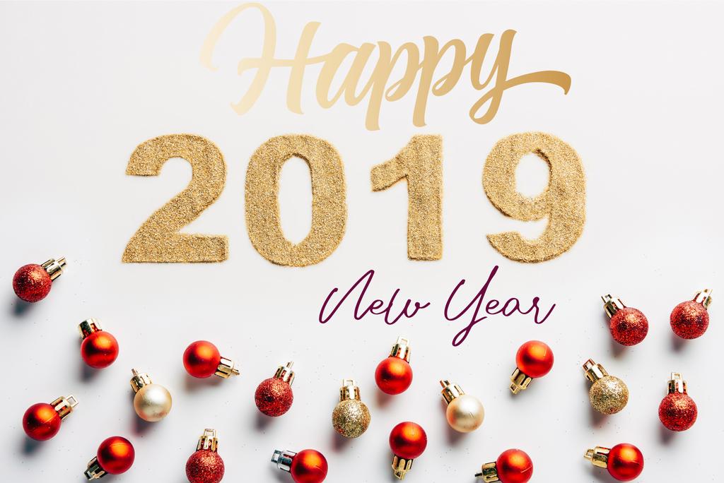 вид зверху на 2019 рік Золотий знак і різдвяні кульки на білому тлі з написом "щасливий новий рік"
 - Фото, зображення