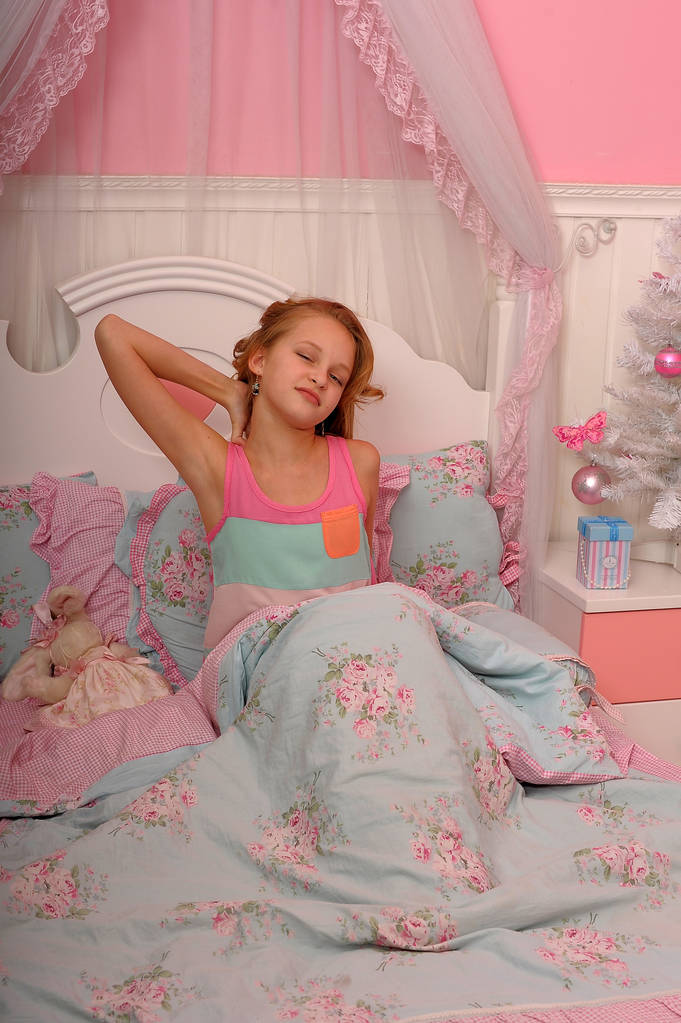 Herääminen tyttö on venyttely sängyssä
 - Valokuva, kuva