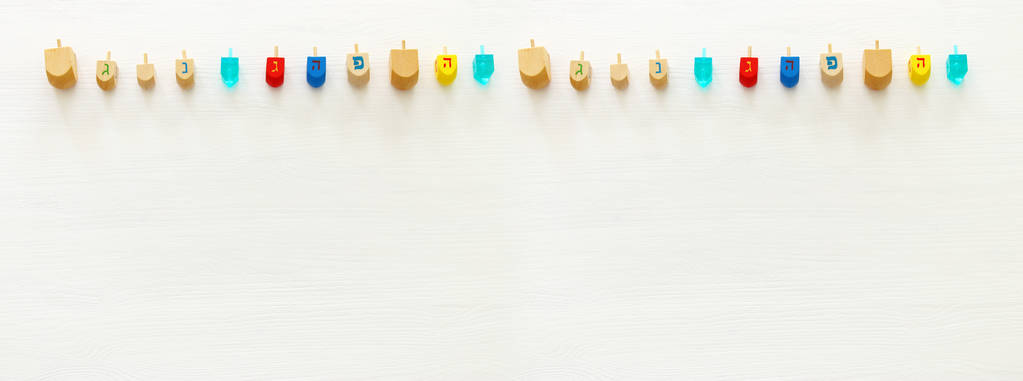 Image of jewish holiday Hanukkah with wooden dreidels colection (spinning top) over white background - Photo, Image