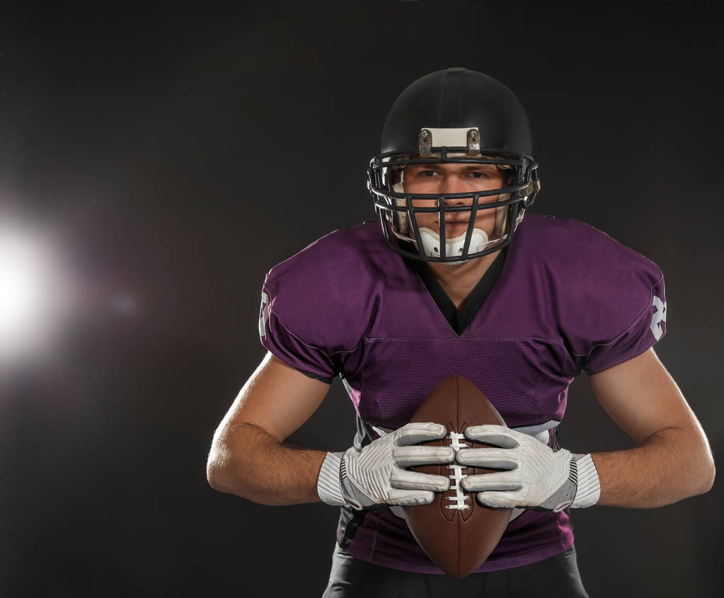 American Football Spieler mit Ball auf dunklem Hintergrund - Foto, Bild