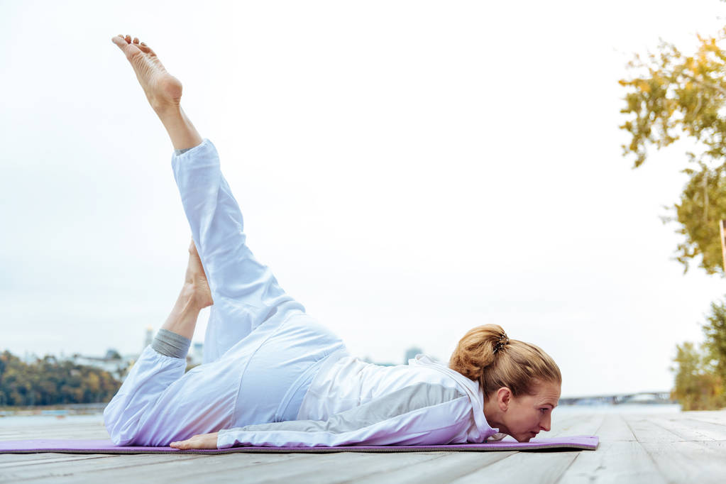 Relaxed young woman easily practicing yoga poses - Photo, Image