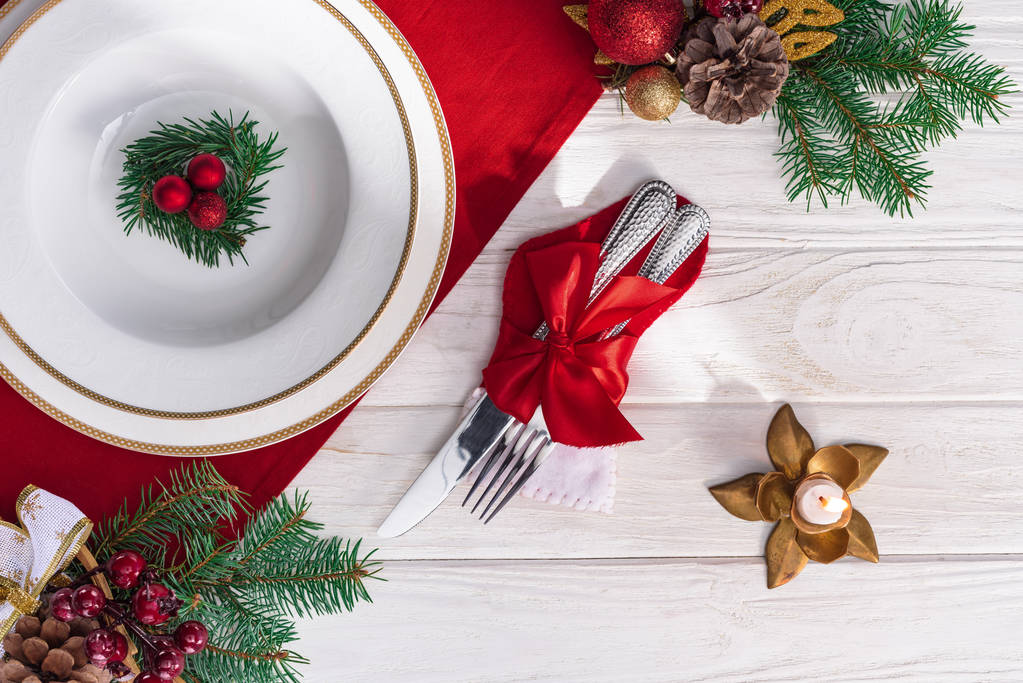 木製のテーブルのキャンドル、フォークとナイフ、プレート、クリスマスの装飾が付いて提供テーブルのトップ ビュー  - 写真・画像