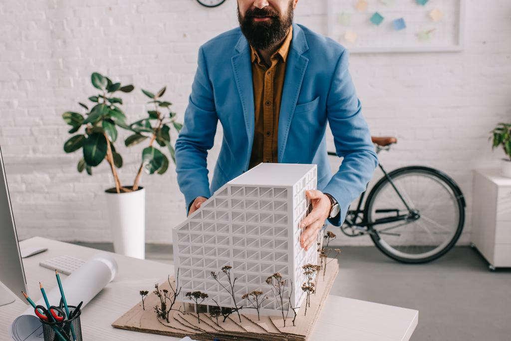 vista cortada do adulto arquiteto masculino em desgaste formal trabalhando no modelo de casa no escritório
 - Foto, Imagem