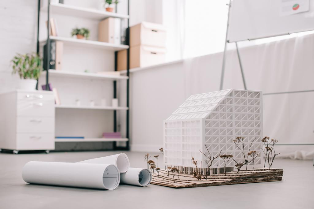 Modernes Architektenbüro-Design mit Bauplänen und Hausmodell im Vordergrund - Foto, Bild