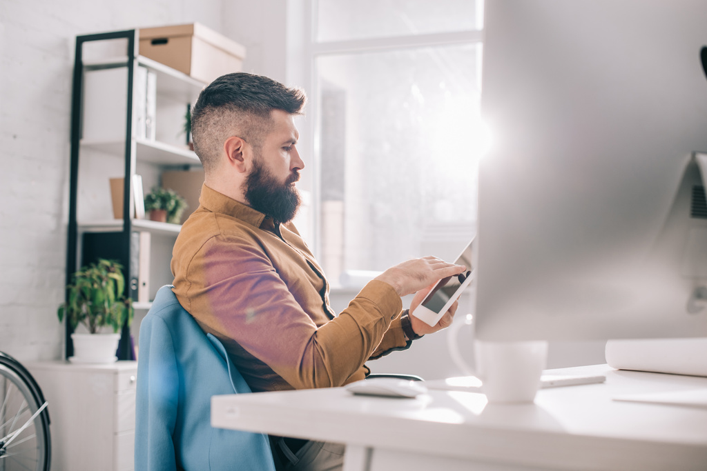 škaredě dospělý muž sedí v kanceláři a používání digitálních tabletu na pracovišti - Fotografie, Obrázek