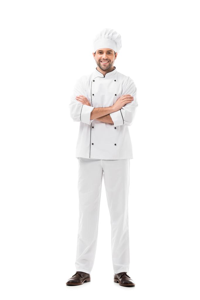 Счастливый молодой шеф-повар со скрещенными руками смотрит на камеру, изолированную на белом
 - Фото, изображение