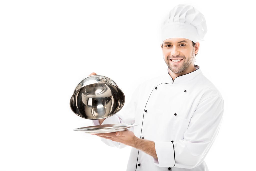 χαμογελαστά σεφ λαμβάνοντας εξυπηρετούν θόλου από πλάκα που απομονώνονται σε λευκό - Φωτογραφία, εικόνα