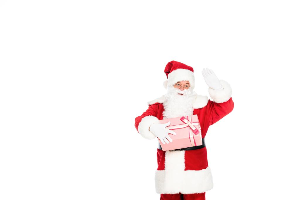 Санта Клаус тримає подарункову коробку і жестикулює на камеру ізольовано на білому
 - Фото, зображення