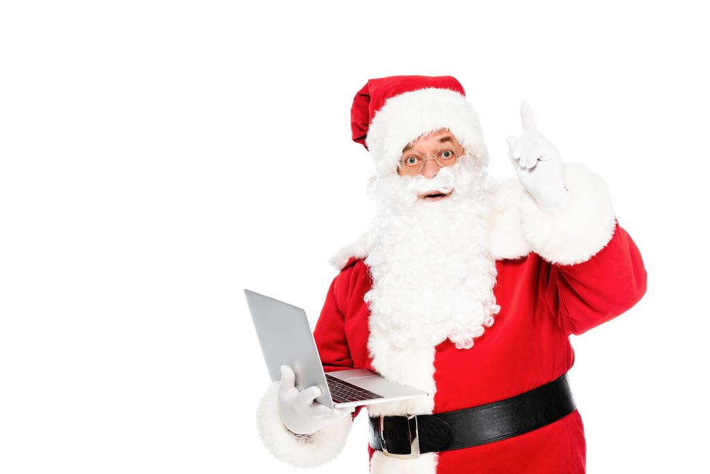 Santa claus trzymając laptop i patrząc na kamery, podczas gdy skierowaną w górę na białym tle - Zdjęcie, obraz