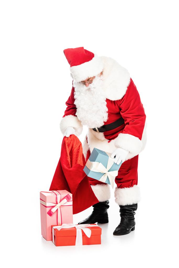 Санта Клаус положить подарки в мешок изолированы на белом
 - Фото, изображение