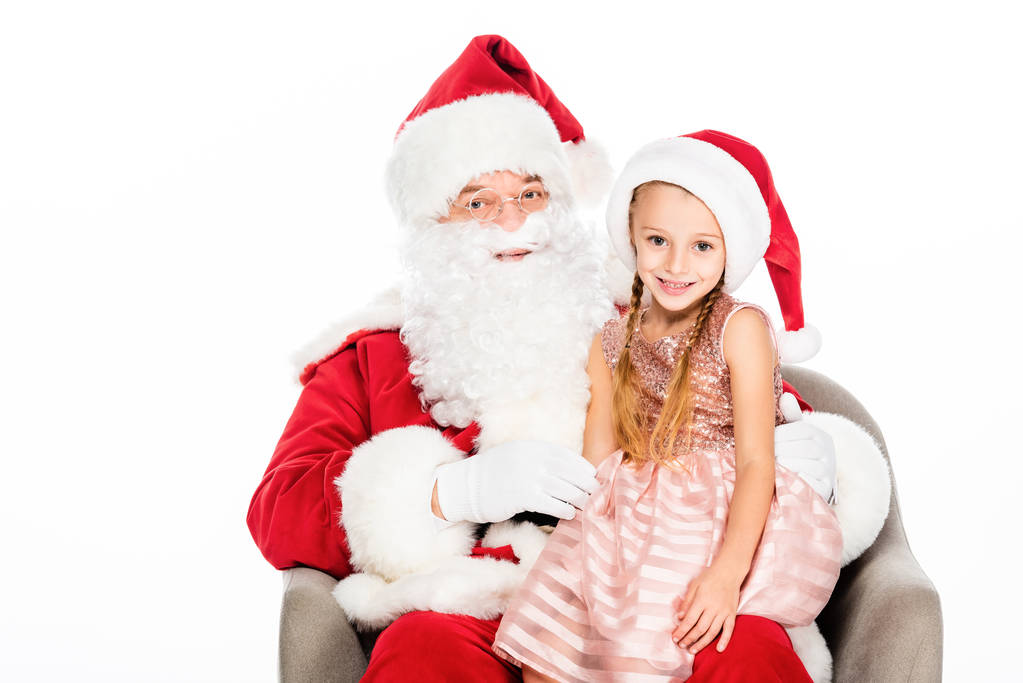 щасливий Санта Клаус і маленька дитина сидить у кріслі разом і дивиться на камеру ізольовано на білому
 - Фото, зображення