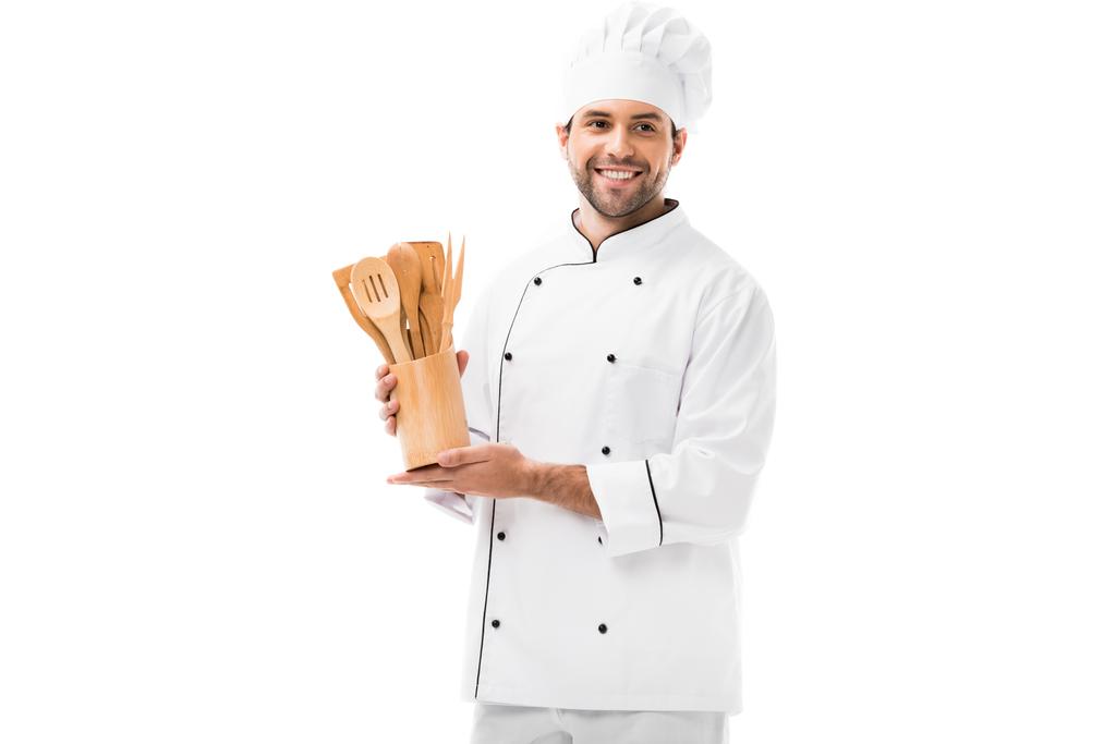 feliz joven chef con montón de utensilios de cocina de madera aislados en blanco
 - Foto, imagen