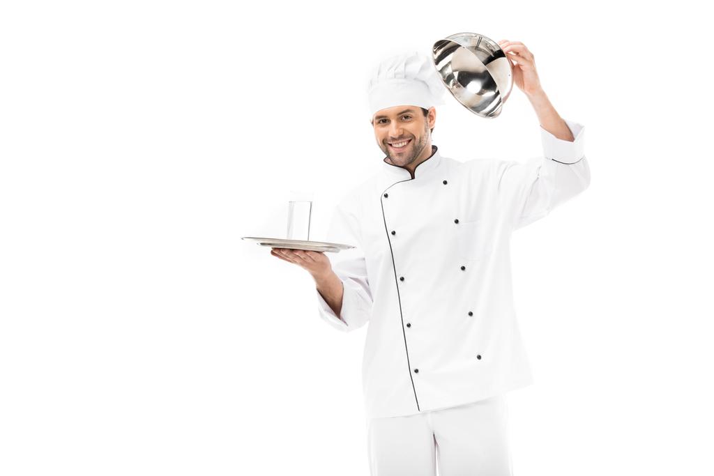 sorridente giovane chef aprendo cupola sezionante con bicchiere d'acqua all'interno isolato su bianco
 - Foto, immagini